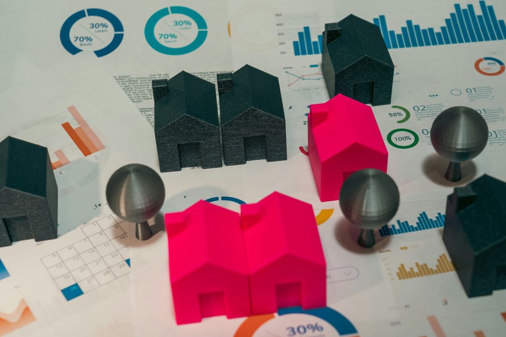 3D-gedruckte Häuser auf Diagrammen, die als Symbol für Inflation Geldanlage, Anlagestrategien, Inflationsschutz und Vermögenssicherung. Tipps zu Investitionen gegen Inflation und Kapitalerhalt.