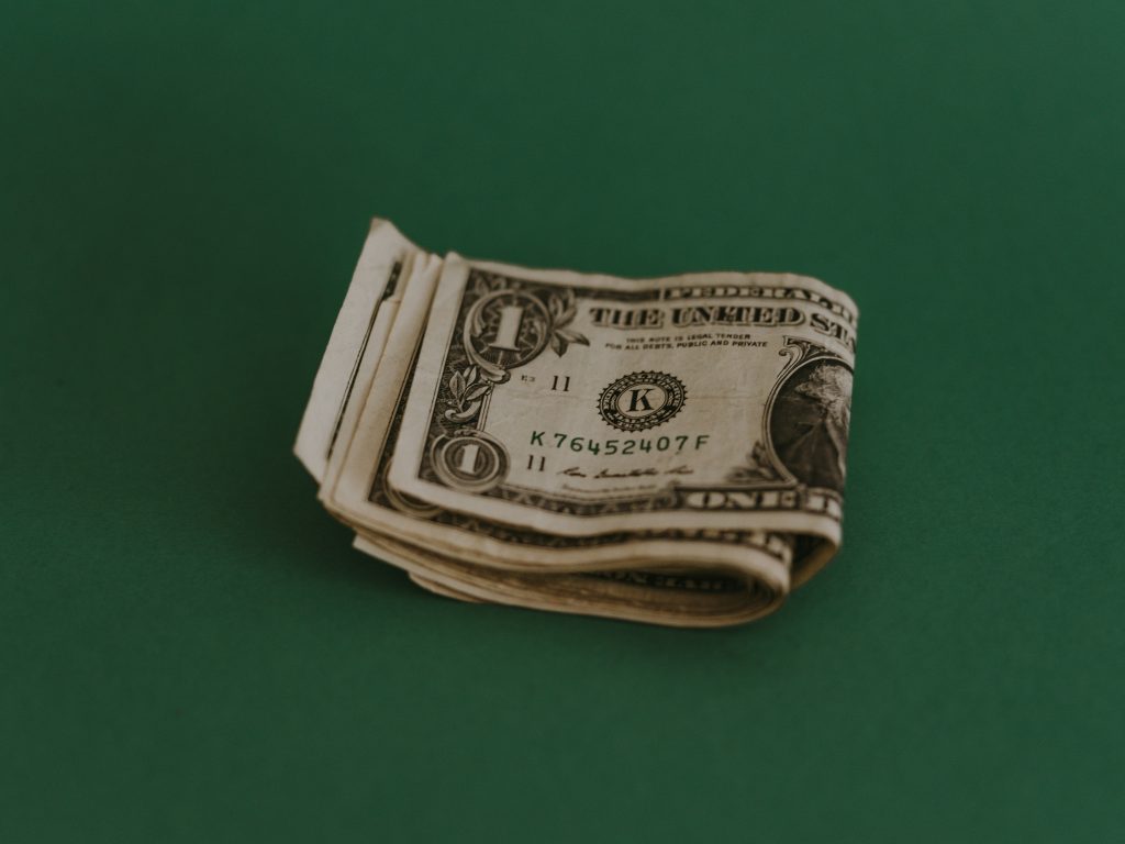 Geld hinter einem grünen Hintergrund – Symbol für Vermögenssicherung, Kapitalerhalt und finanzielle Entscheidungen im Kontext von Geldanlage und Finanztipps.